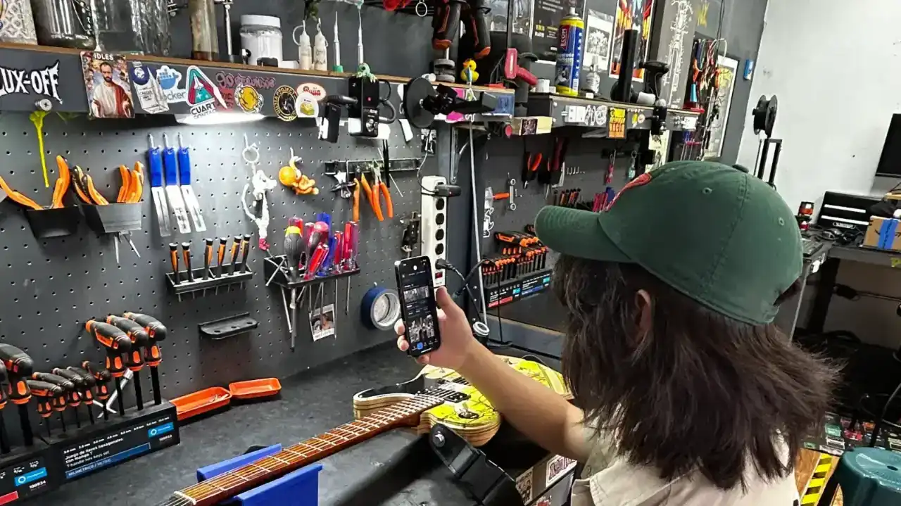 Un taller de instrumentos: el banco de trabajo, el tablero de herramientas y una guitarra en el soporte